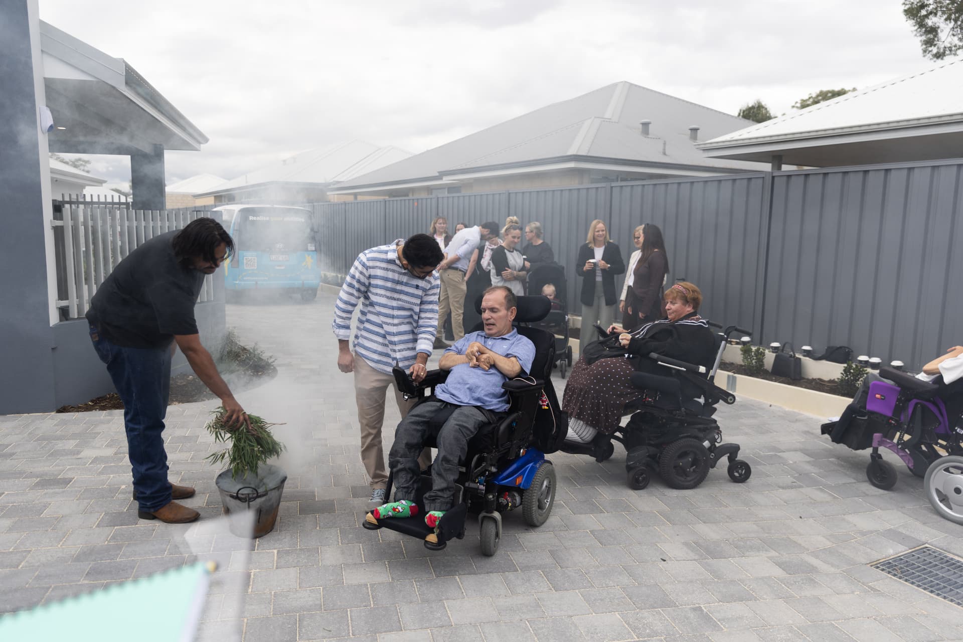 A traditional smoking ceremony at the Kenwick SDA opening, with residents and guests gathered in the new courtyard