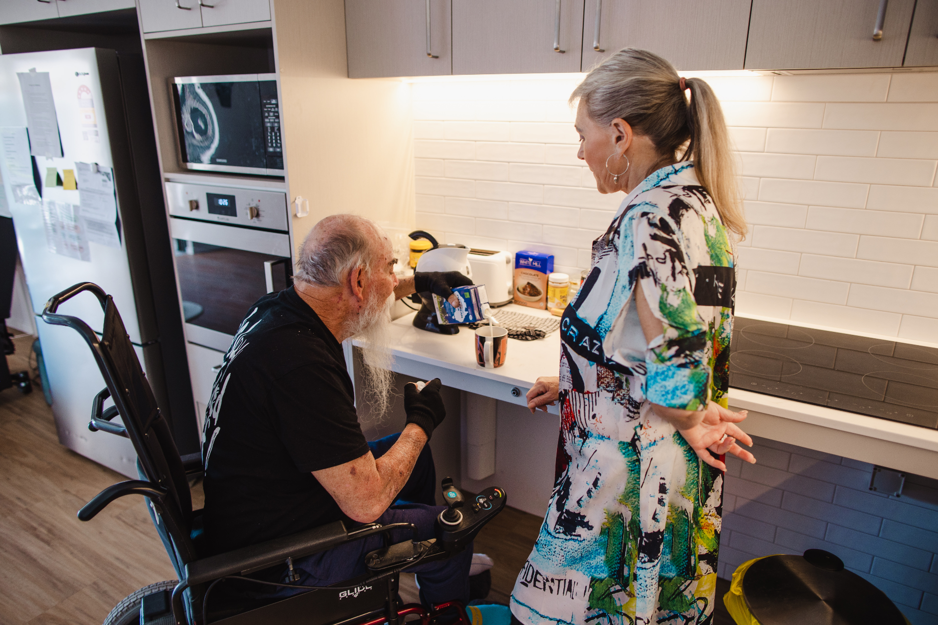 Resident in a Pulse NDIS SDA accessible kitchen in Perth, with lowered benchtop and assistive design supporting independent living